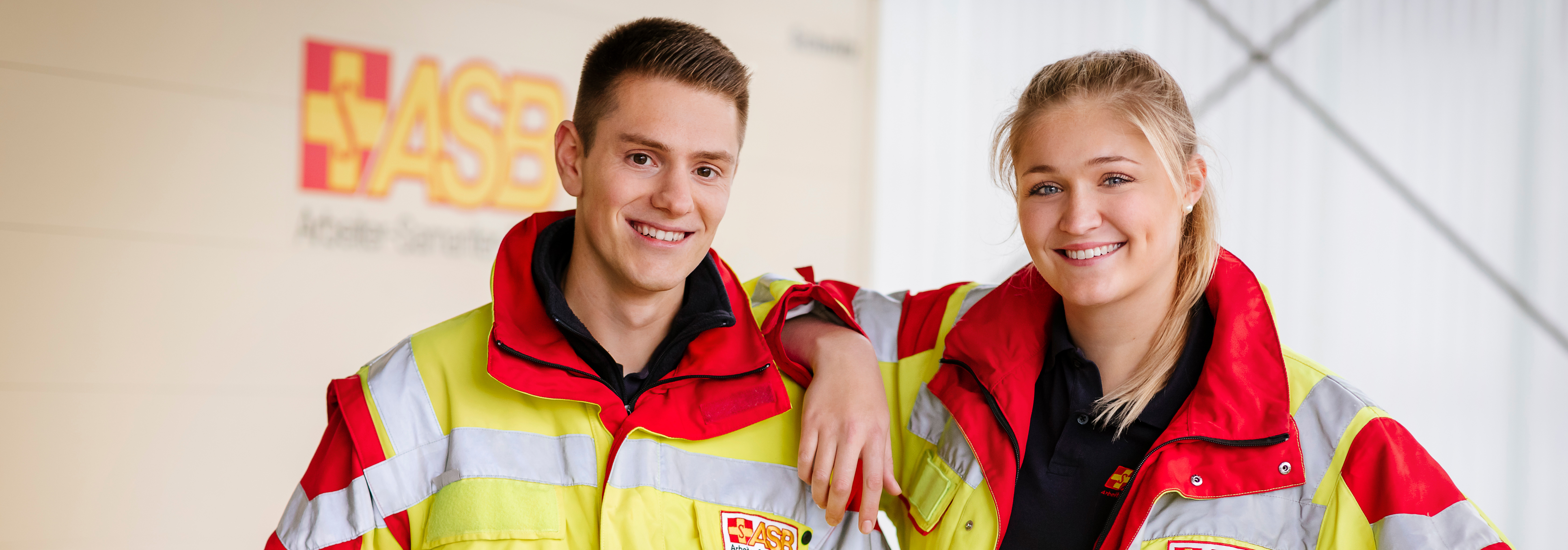 Zwei Rettungssanitäter des ASB Bremens stehen vor Christoph 6 und einem Rettungswagen