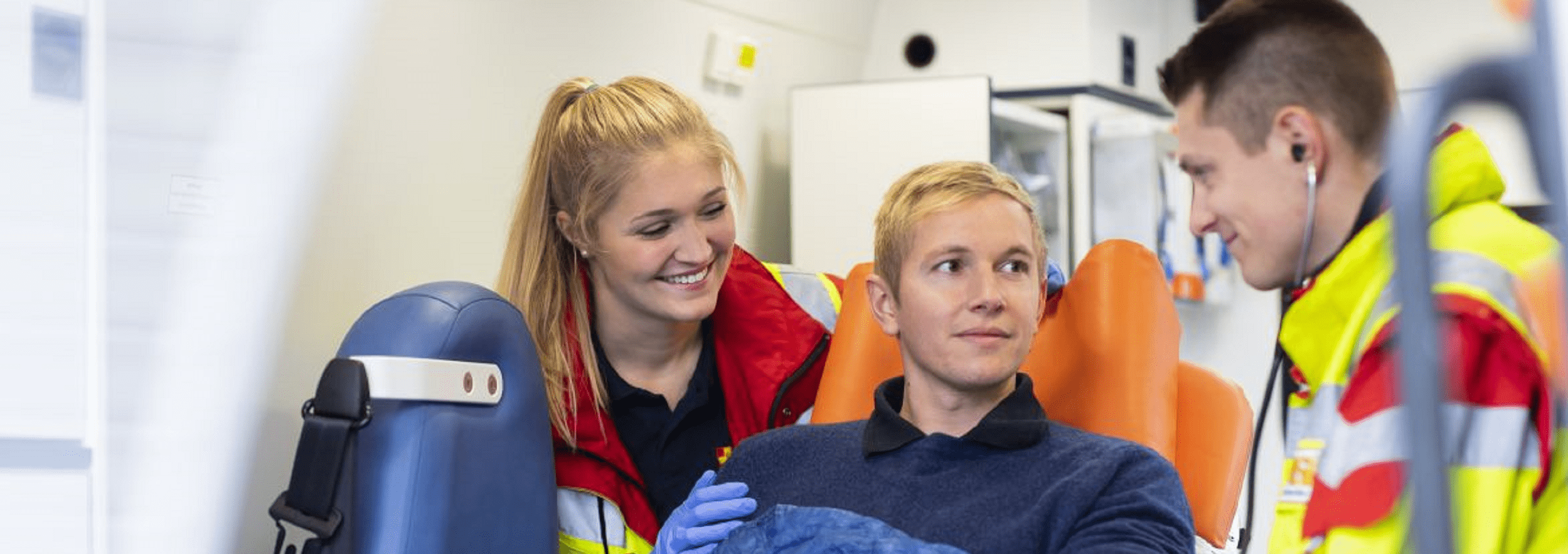 Zwei Rettungssanitäter des ASB Bremens stehen vor Christoph 6 und einem Rettungswagen