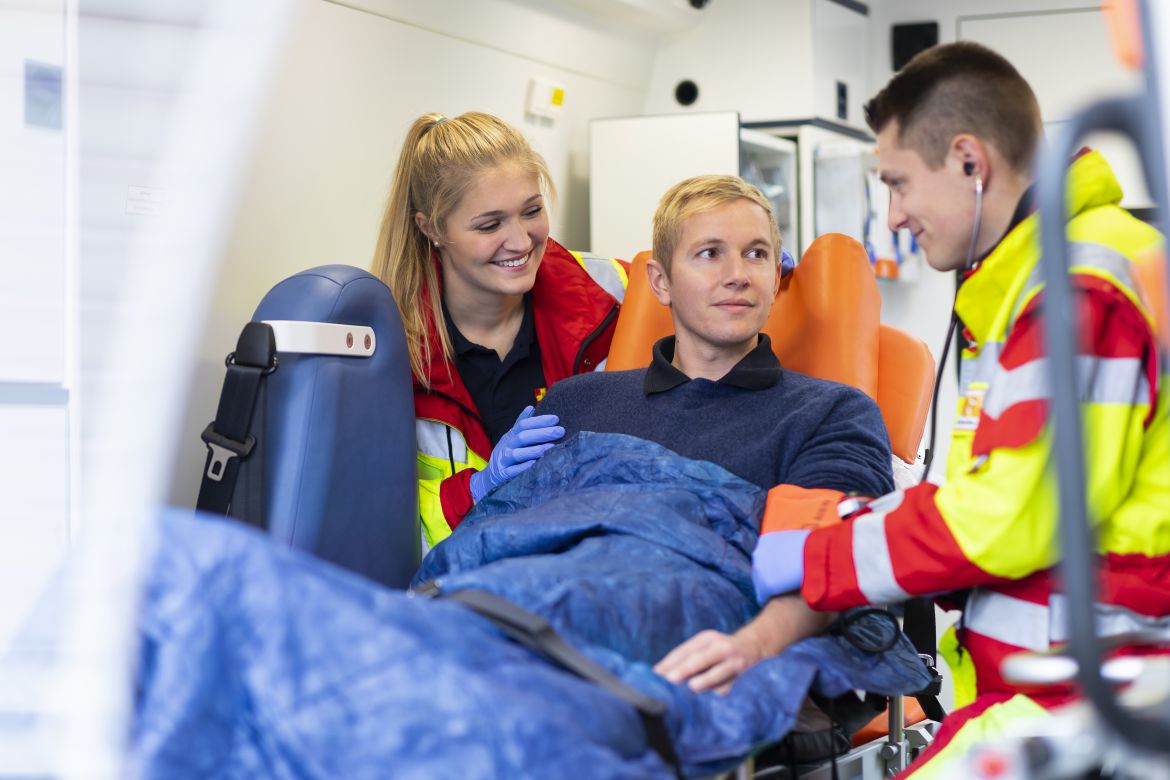 Zwei Rettungssanitäter des ASB Bremens stehen vor Christoph 6 und einem Rettungswagen