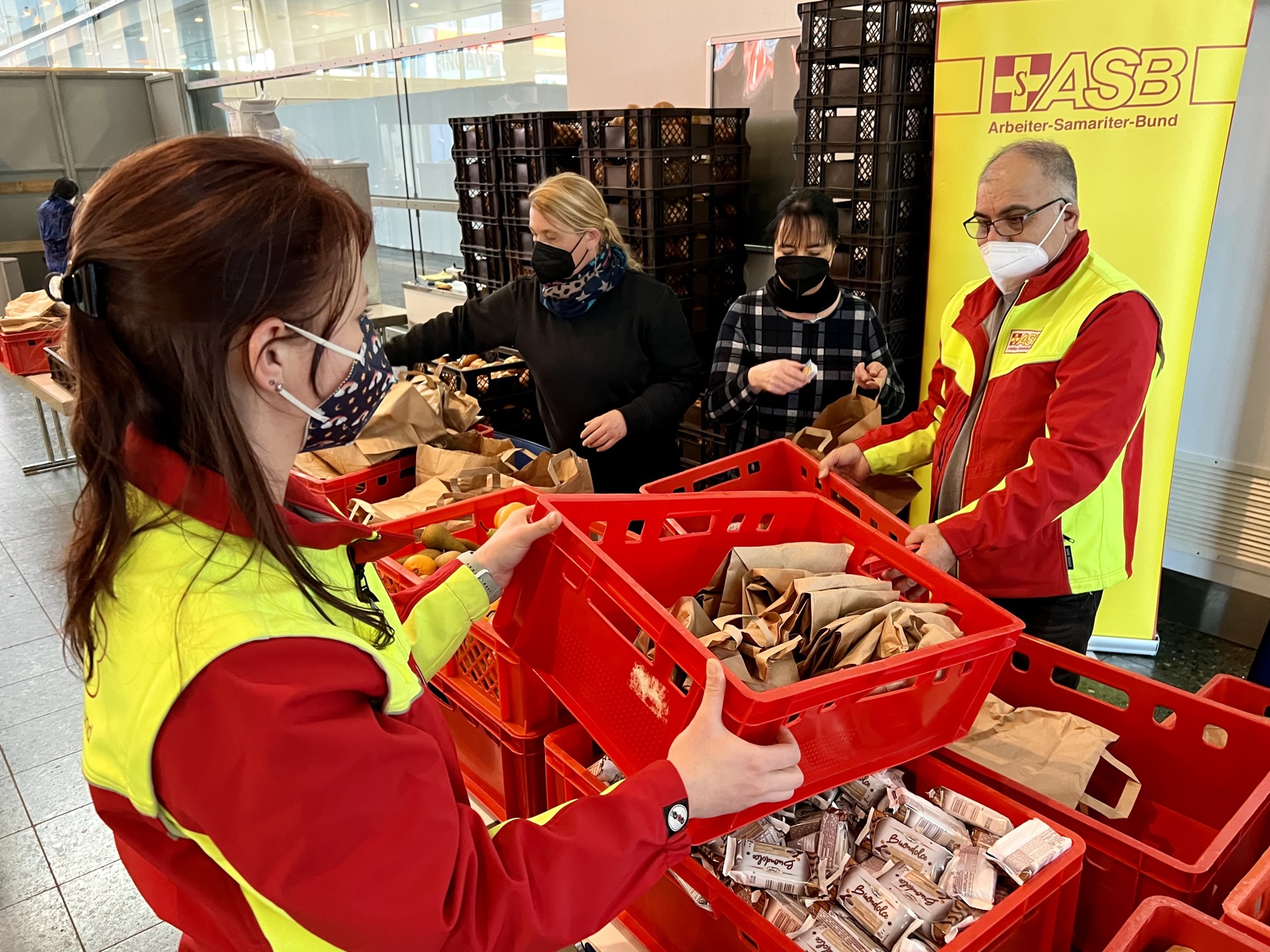 Helfer:innen des ASB Bremen beim Packen der Frühstückstüten in der Messehalle 6 auf der Bremer Bürgerweide